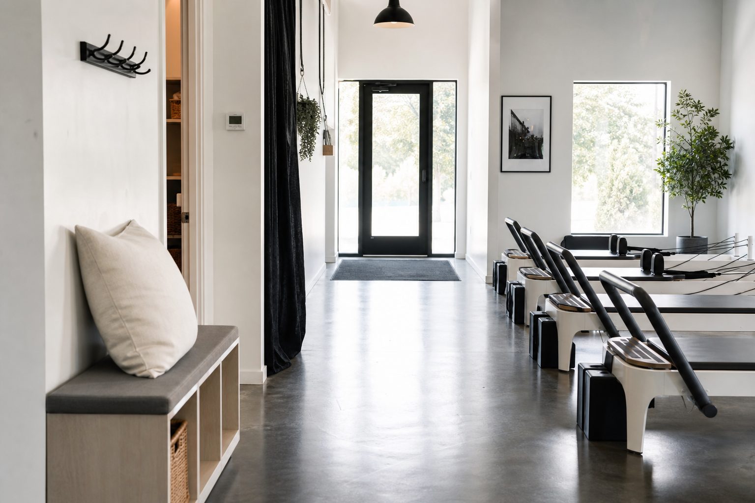 Bright studio hallway with a clear exit path and open aisle running alongside reformers